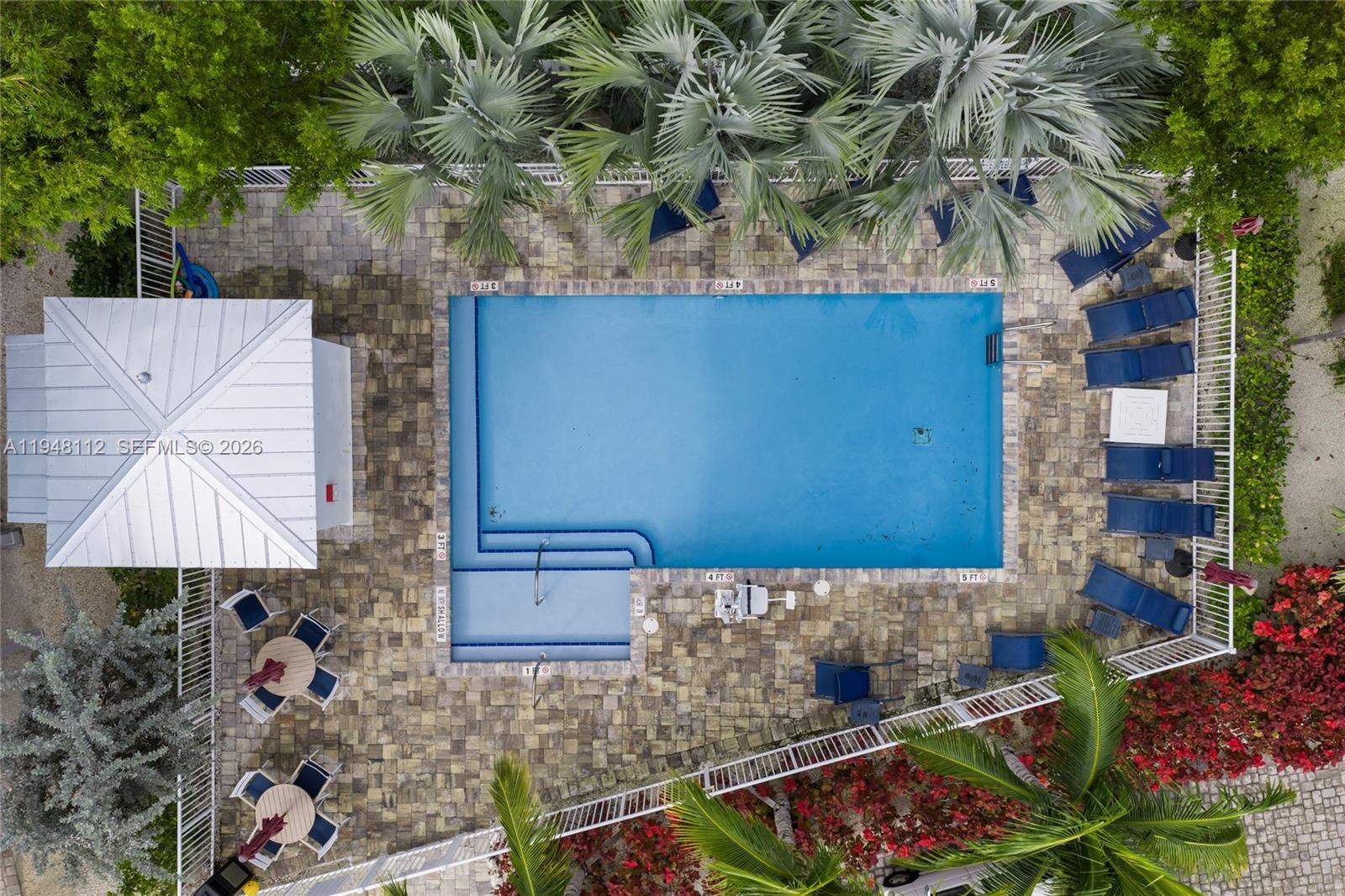 An aerial view shows a rectangular swimming pool with a shallow entry area and patio — 101 11th Street Ocean, Unit 17, Marathon FL 33050, MARATHON, FL