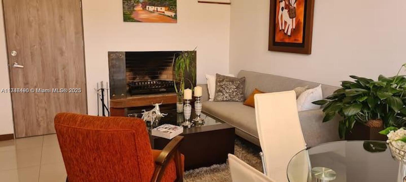 A living room features a fireplace, a sofa, an orange armchair, and a dining table — cra 71 PONTEVEDRA, C 111121, C