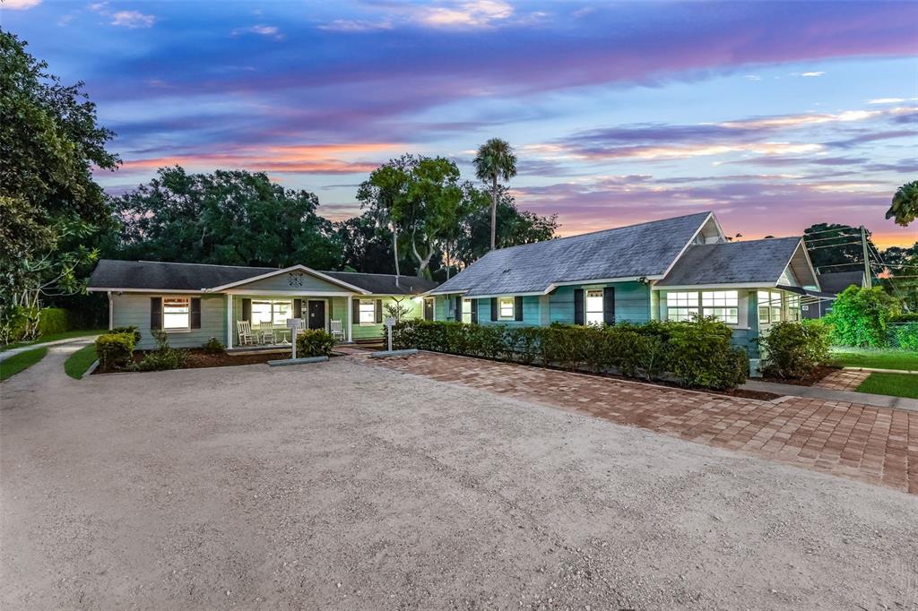 A light green house with a gravel driveway and a brick walkway at sunset — 330 S HIGHLAND STREET, MOUNT DORA, FL