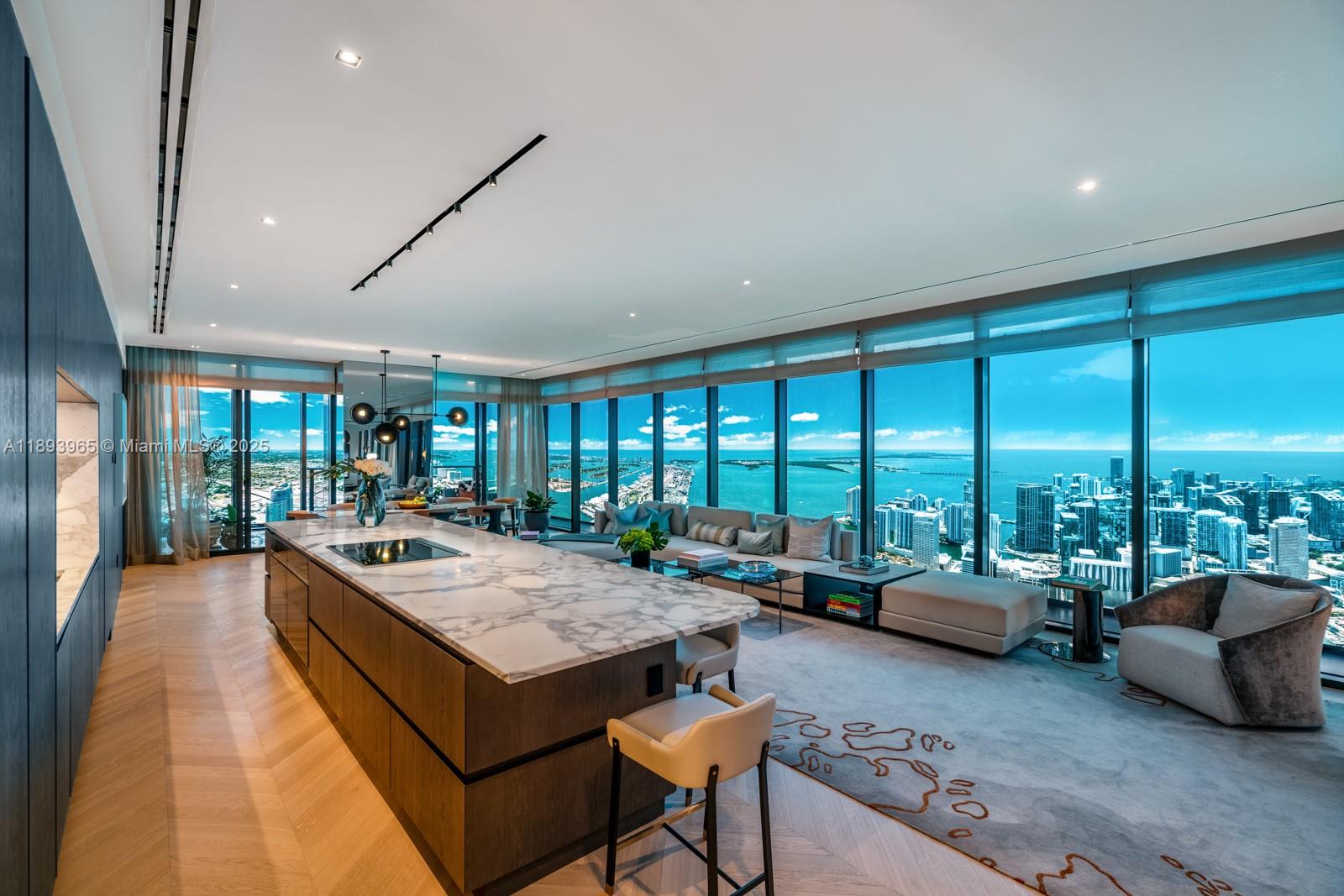 A modern open-plan kitchen and living area features a marble island and floor-to-ceiling windows — 300 N Biscayne Blvd # 7803, Miami FL 33132, MIAMI, FL
