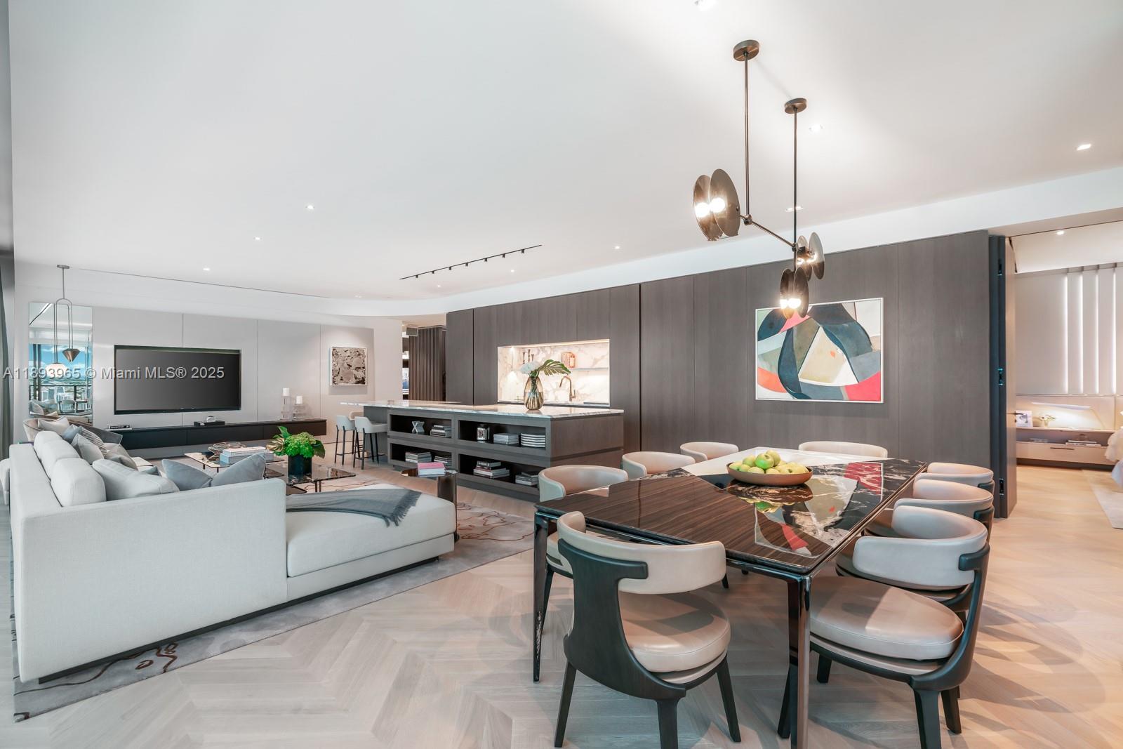 An open-concept living and dining area features a modern kitchen, dark wood paneling, and herringbone flooring — 300 N Biscayne Blvd # 7803, Miami FL 33132, MIAMI, FL