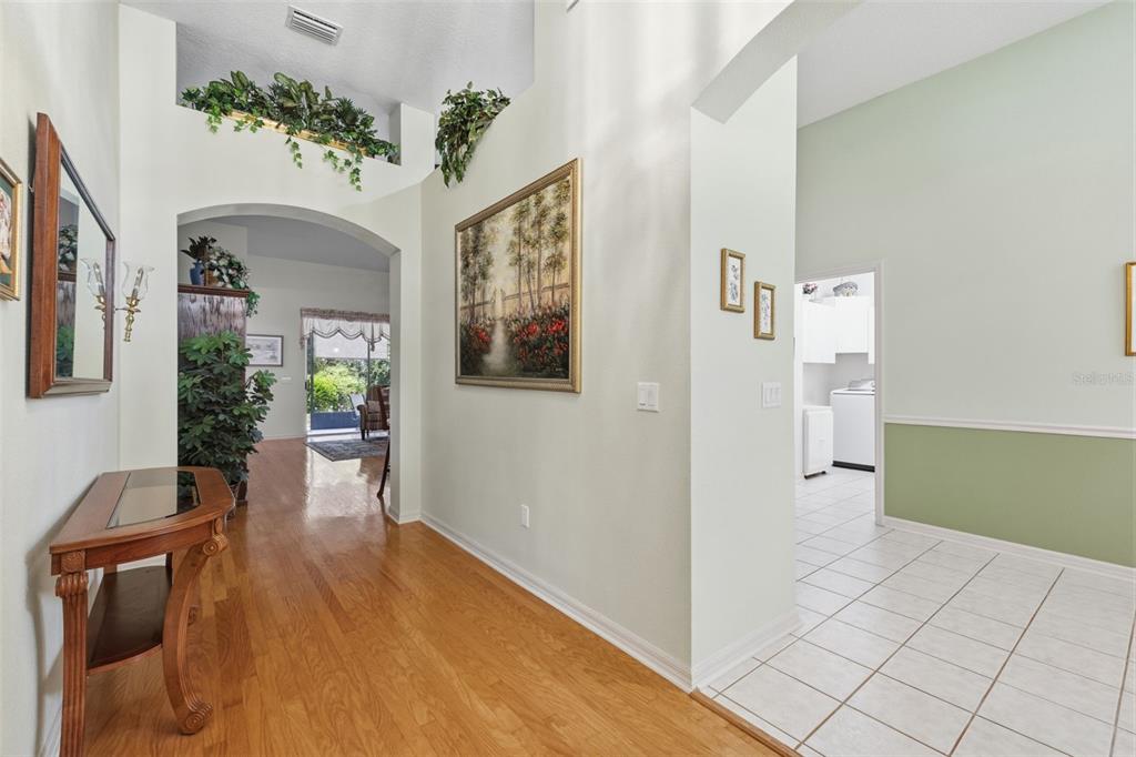 A foyer with hardwood floors leads to a tiled area and an arched entryway — 19720 MORDEN BLUSH DRIVE, LUTZ, FL