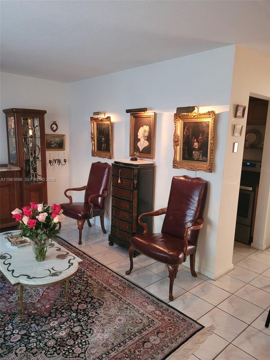 A living room features two leather armchairs, a marble coffee table, and framed wall art — 3881 W Flagler St # 208, Miami FL 33134, MIAMI, FL