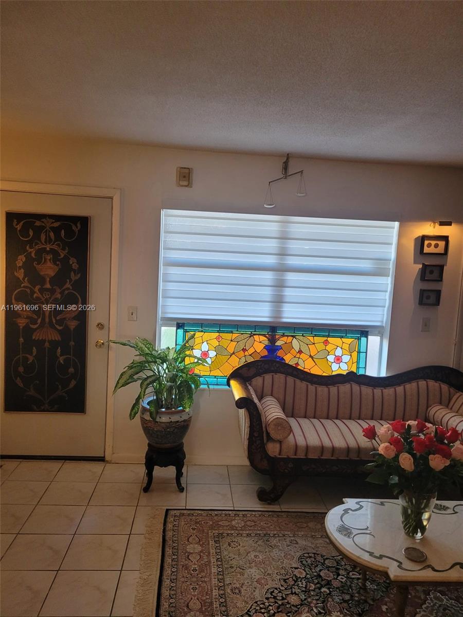 A living room features a stained glass window, a striped sofa, and a decorative door — 3881 W Flagler St # 208, Miami FL 33134, MIAMI, FL