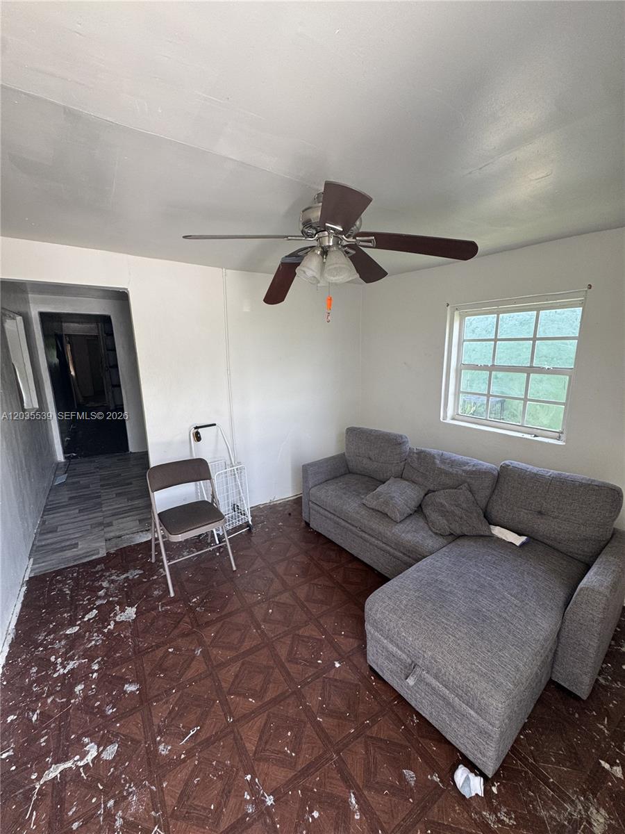 A living room features a gray sectional sofa, a ceiling fan, and worn tile flooring — 2125 W 5th Ave, Hialeah FL 33010, HIALEAH, FL