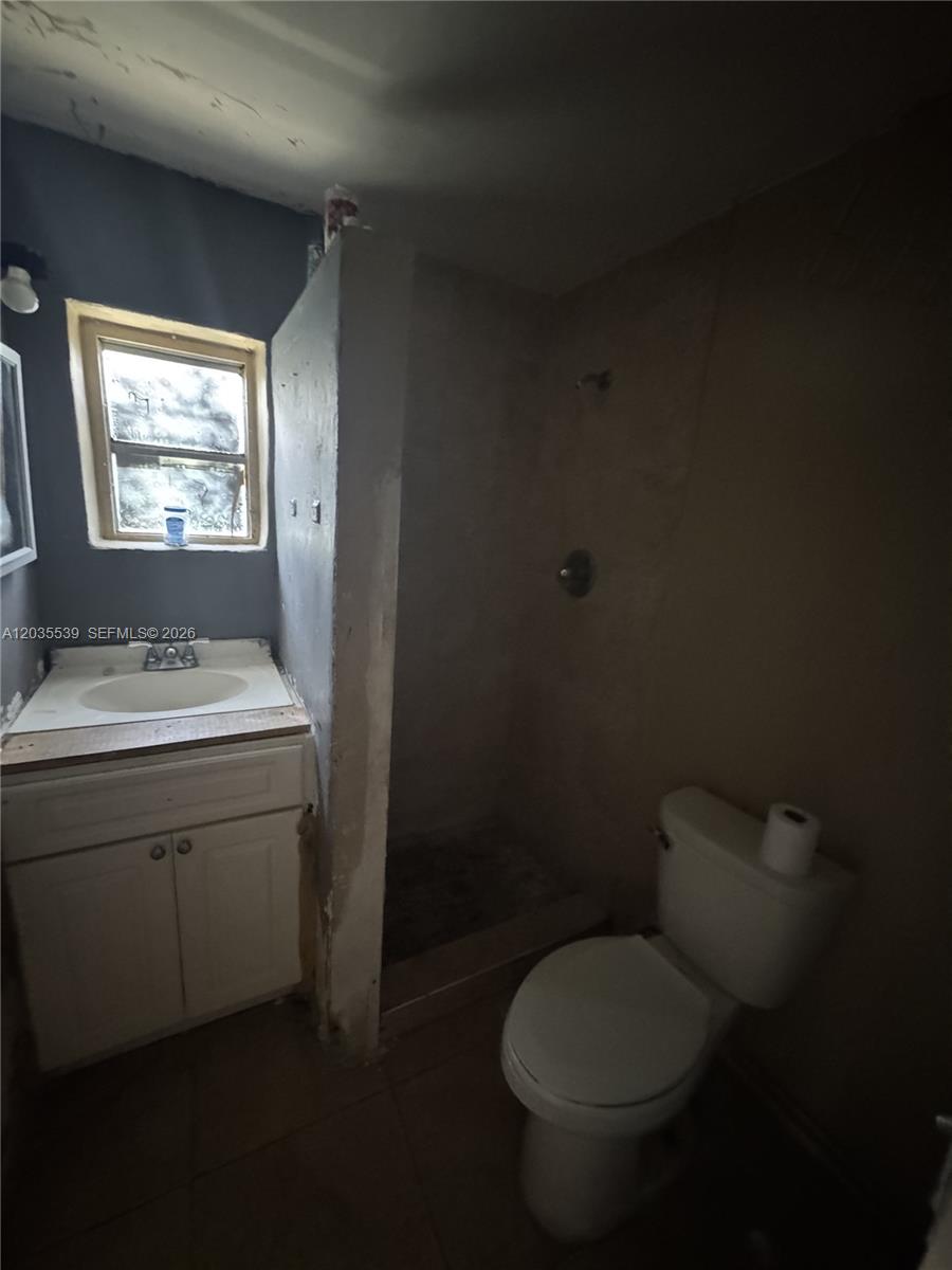 A bathroom features a vanity, a toilet, and an unfinished shower stall with bare walls — 2125 W 5th Ave, Hialeah FL 33010, HIALEAH, FL