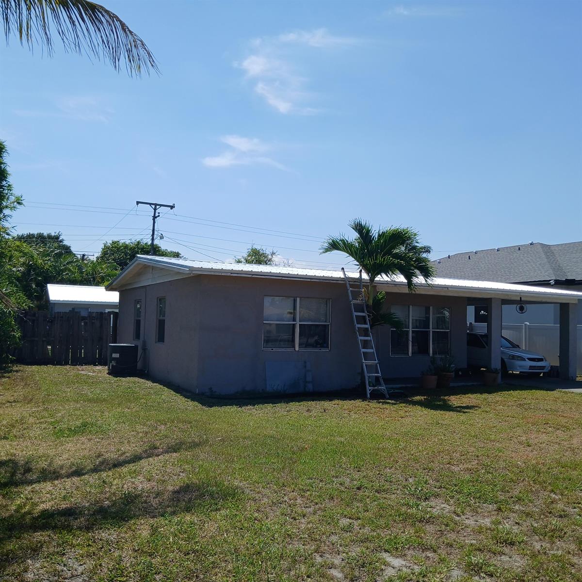 A single-story house with a metal roof, a ladder, and a carport on a lawn — 811 S Broadway, Lantana FL 33462, LANTANA, FL
