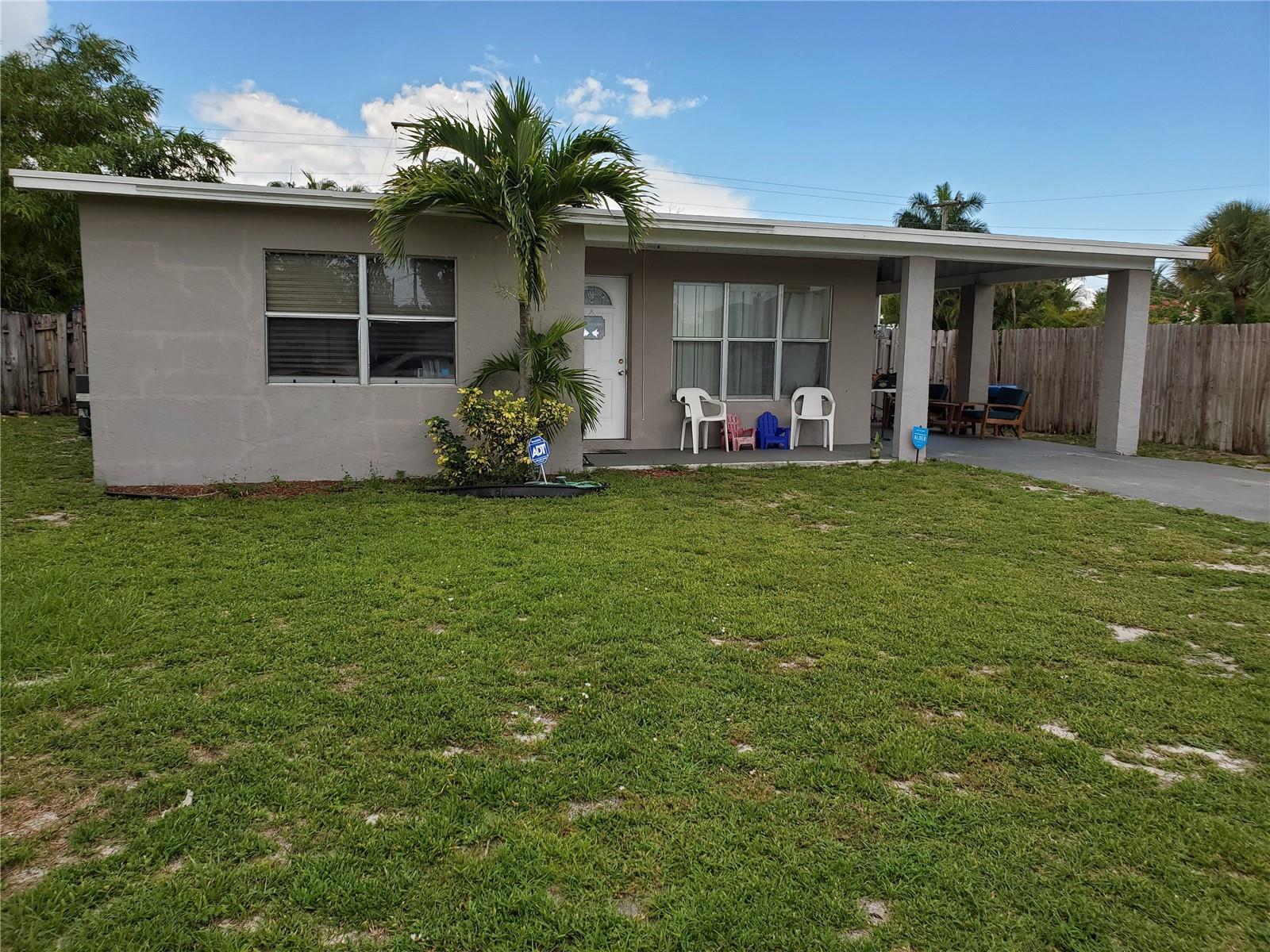 A single-story gray house with a palm tree, front porch, and attached carport — 811 S Broadway, Lantana FL 33462, LANTANA, FL