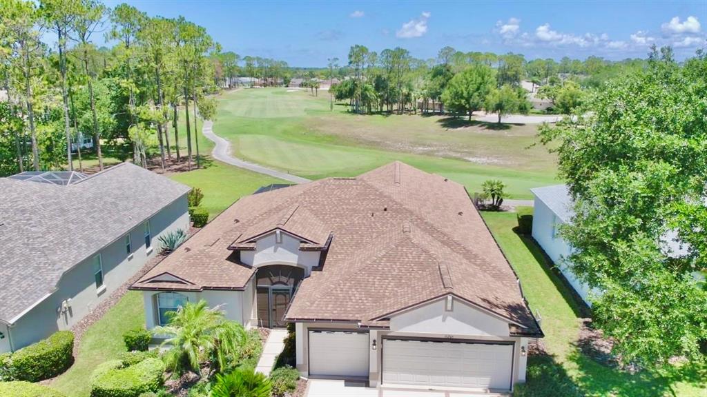 An aerial view of a suburban house with a shingled roof overlooking a golf course — 11205 EDGE PARK DRIVE, HUDSON, FL