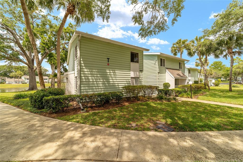 A two-story light green apartment building with horizontal siding sits on a grassy lawn — 557 MIDWAY DRIVE UNIT B, OCALA, FL