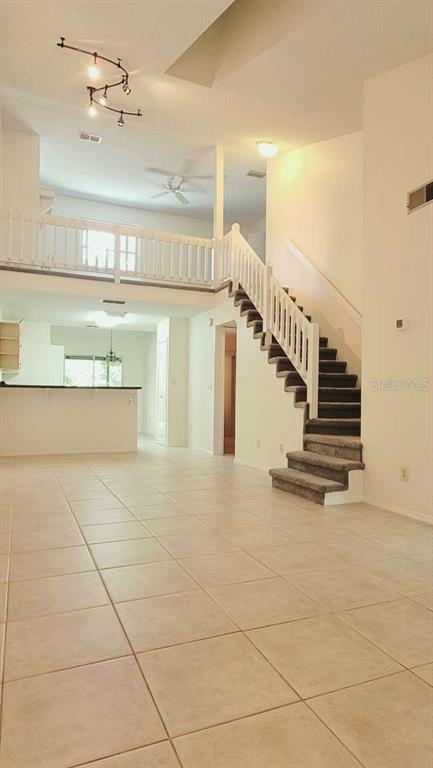 A bright living area features tile flooring, a staircase with white railings, and a loft overlook — 5801 RED CEDAR LANE, TAMPA, FL