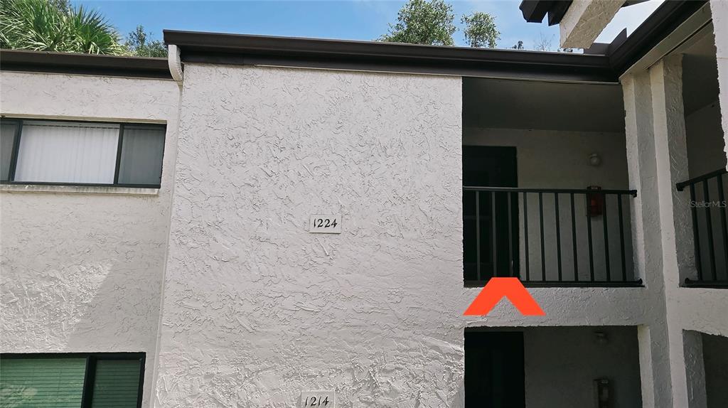 An exterior view of a two-story apartment building with stucco walls and a balcony — 700 STARKEY RD UNIT 1224, LARGO, FL