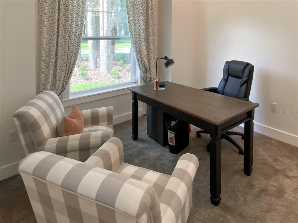 A home office features a dark wood desk, two plaid armchairs, and a large window — 904 AZALEA WALK CIRCLE, DELAND, FL