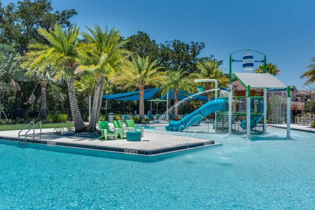 A swimming pool features a water slide, a splash pad area, and palm trees — 2468 RAMA DRIVE, KISSIMMEE, FL