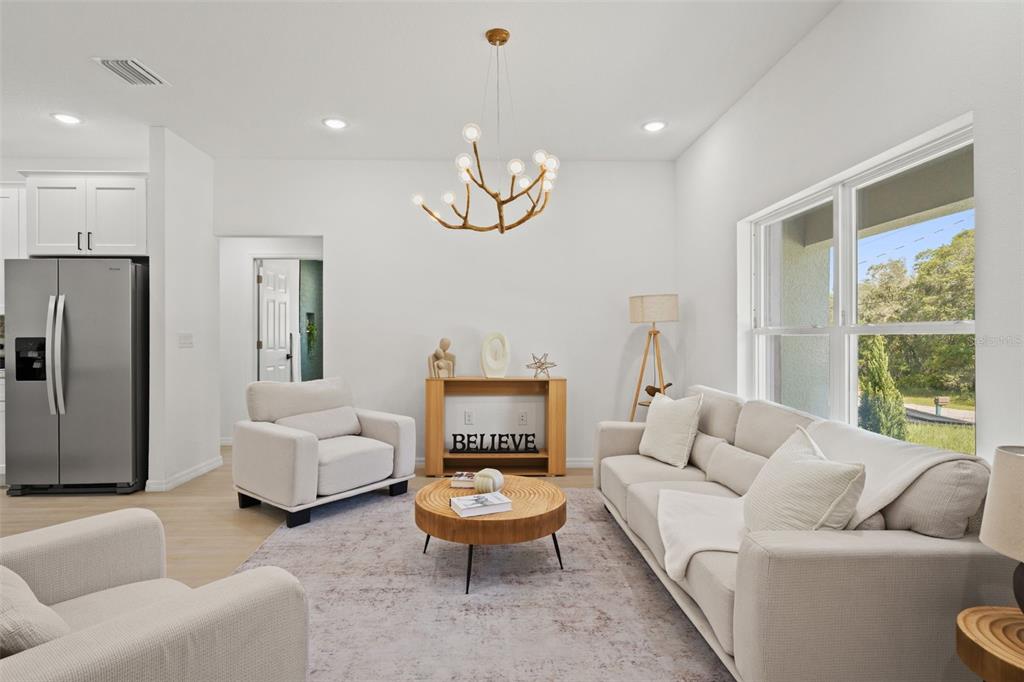 A living room features a light-colored sofa, two armchairs, a round coffee table, and a chandelier — 2784 W PARAGON, CITRUS SPRINGS, FL