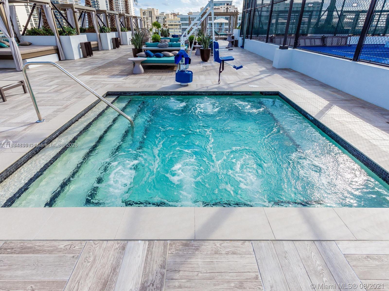A rectangular hot tub with jets sits on a tiled deck near outdoor lounge seating — 4010 S Ocean Dr # R401, Hollywood FL 33019, HOLLYWOOD, FL