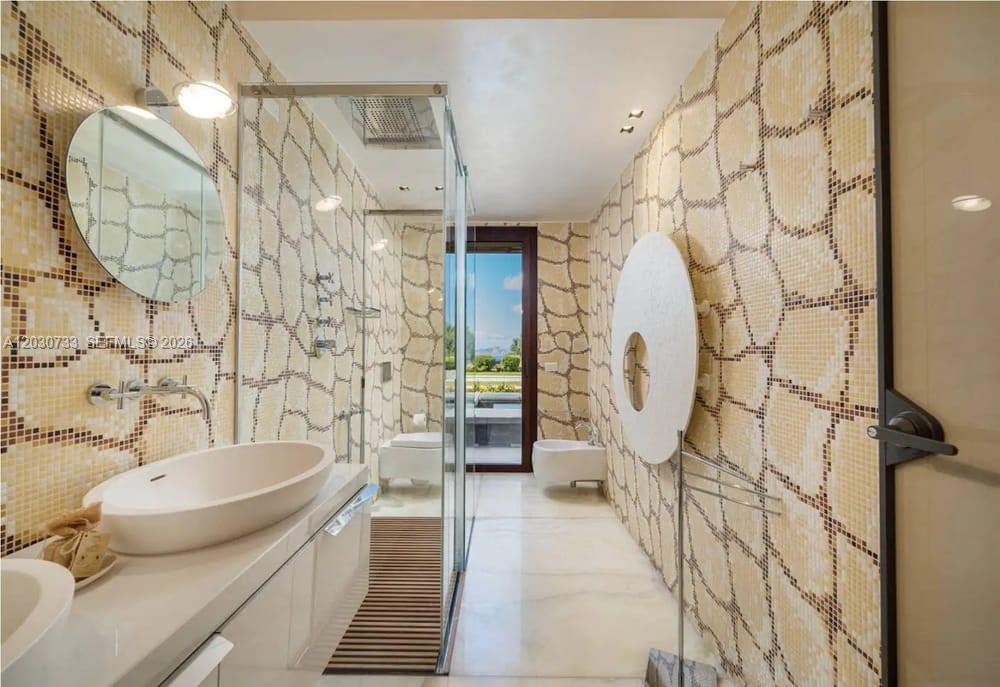 A modern bathroom features mosaic-tiled walls, a glass-enclosed shower, a vessel sink, and a bidet — Sardinia Luxury Estate Porto Cervo Max Mlekus, FL