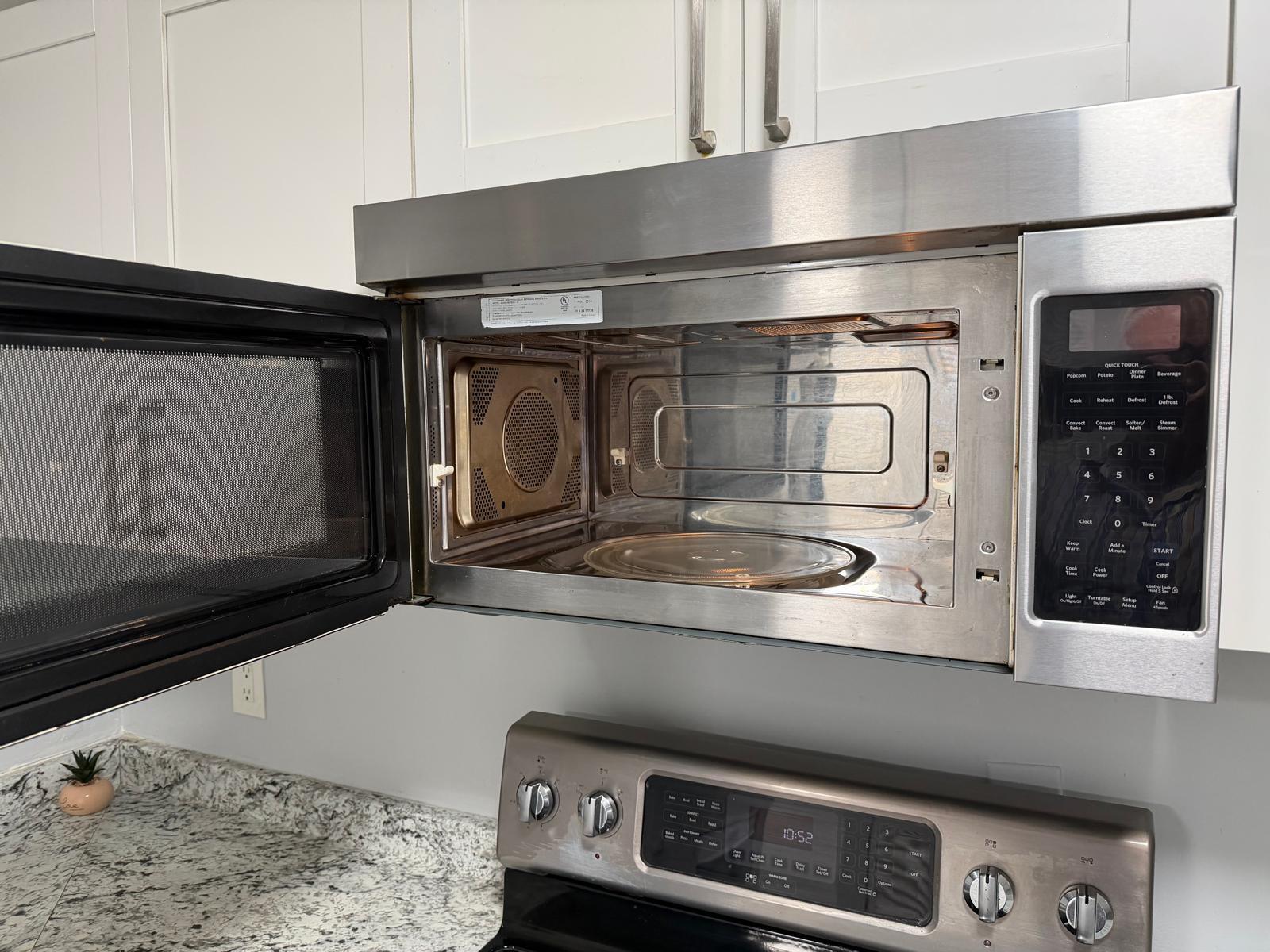A stainless steel over-the-range microwave is mounted above a stainless steel stove in a kitchen — 615 S State Road 7 # 1d, Margate FL 33068, MARGATE, FL