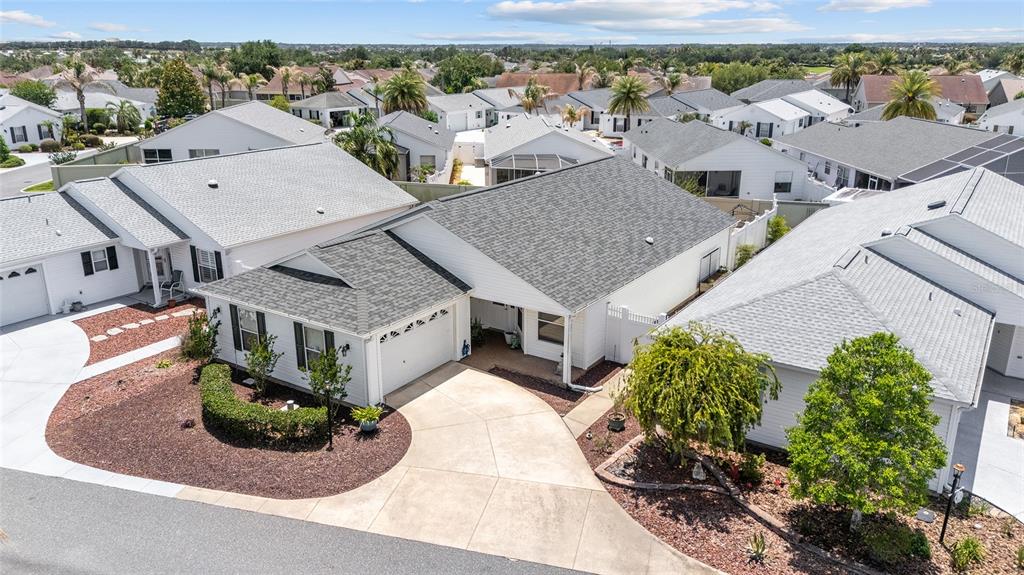 An aerial view shows a white single-story house with a gray shingled roof and driveway — 418 FLOSSMOOR COURT, THE VILLAGES, FL