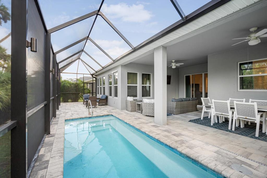 A modern kitchen features white cabinetry, a large central island, and light-colored tile flooring — 5640 TREVESTA PLACE, PALMETTO, FL