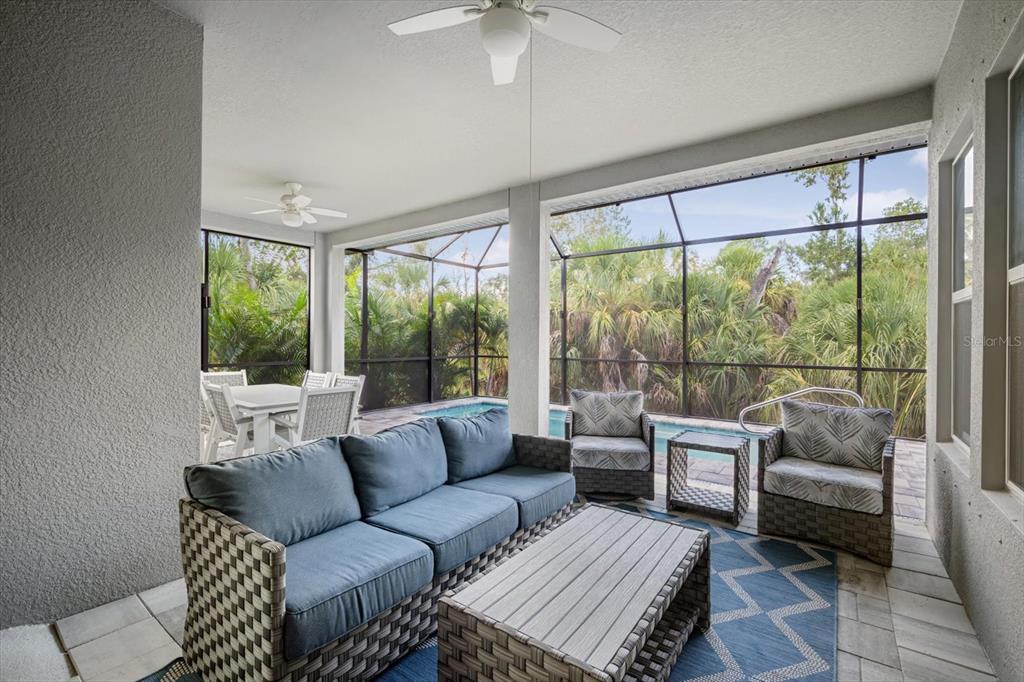 A modern kitchen features white cabinetry, stainless steel appliances, a large island, and tile flooring — 5640 TREVESTA PLACE, PALMETTO, FL