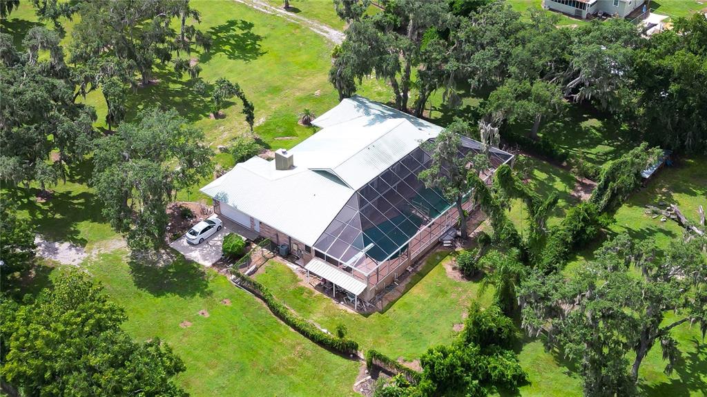 An aerial view shows a single-story house with a metal roof and a screened-in pool — 914 S MILLER ROAD, VALRICO, FL