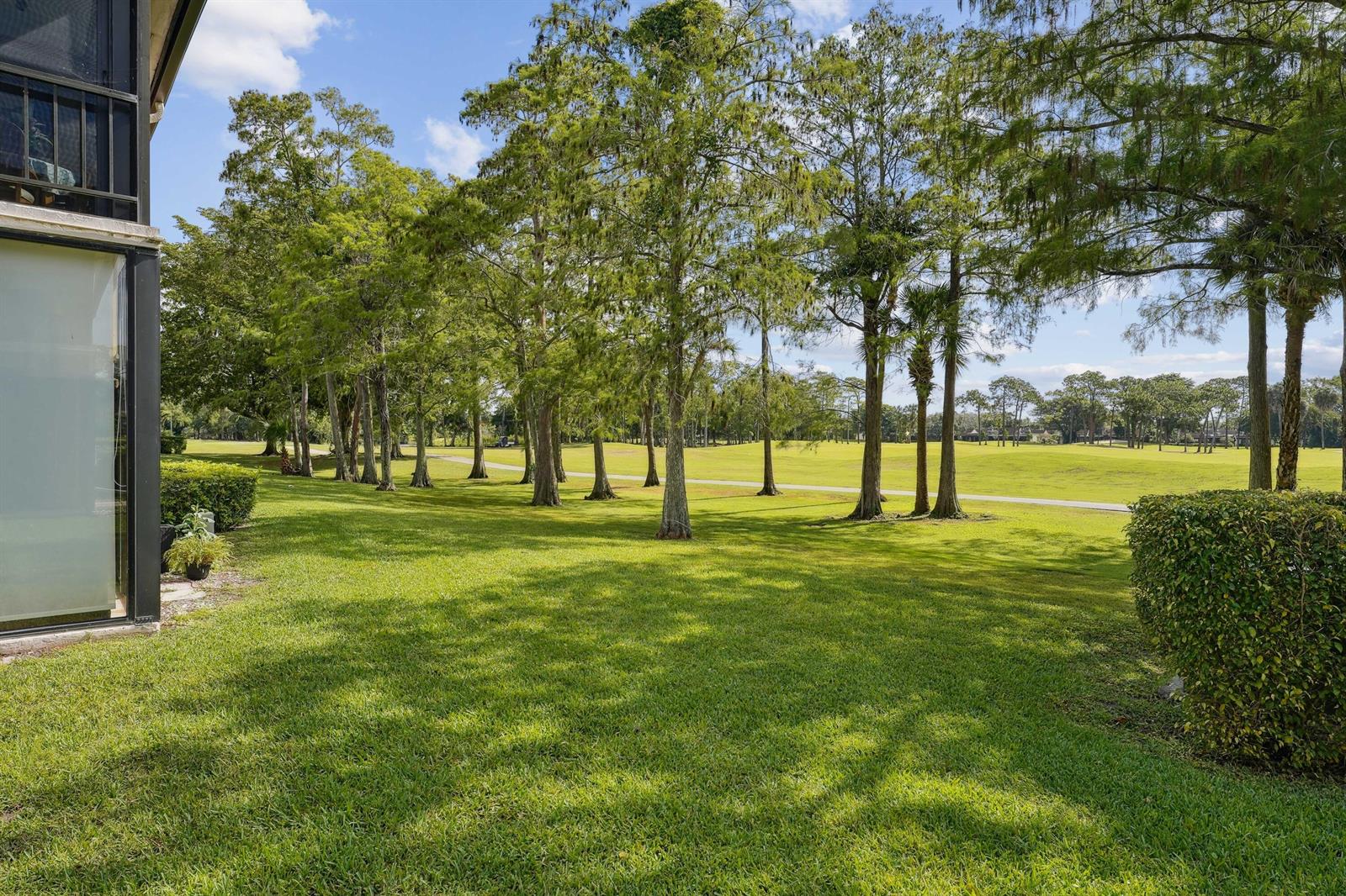 A view of a grassy lawn and a line of trees bordering a golf course — 21650 Juego Circle # 24b, Boca Raton FL 33433, BOCA RATON, FL