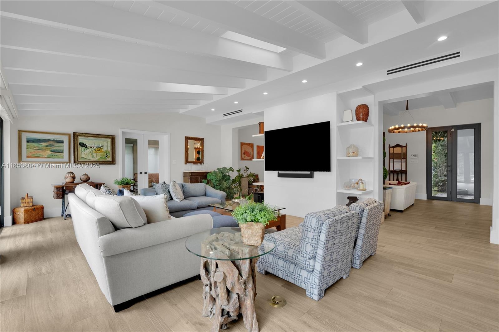 A bright living room features a vaulted ceiling, light wood floors, and a wall-mounted television — 4475 N Meridian Ave, Miami Beach FL 33140, MIAMI BEACH, FL