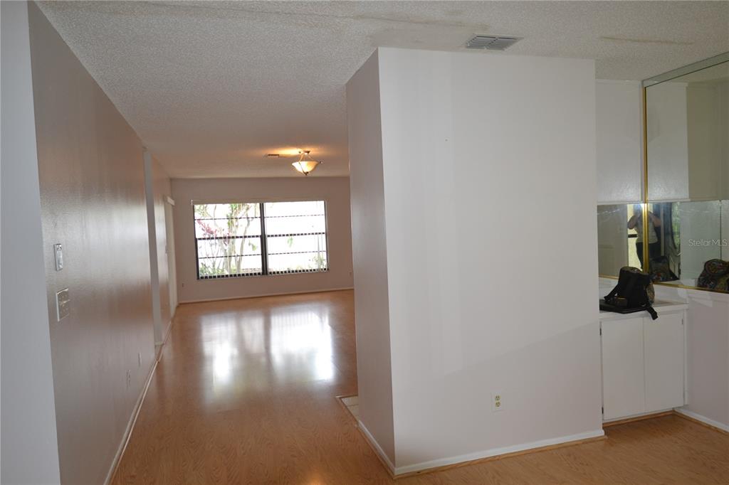 A view of a living area with light wood flooring, white walls, and a window — 2001 DOVER COURT, OLDSMAR, FL