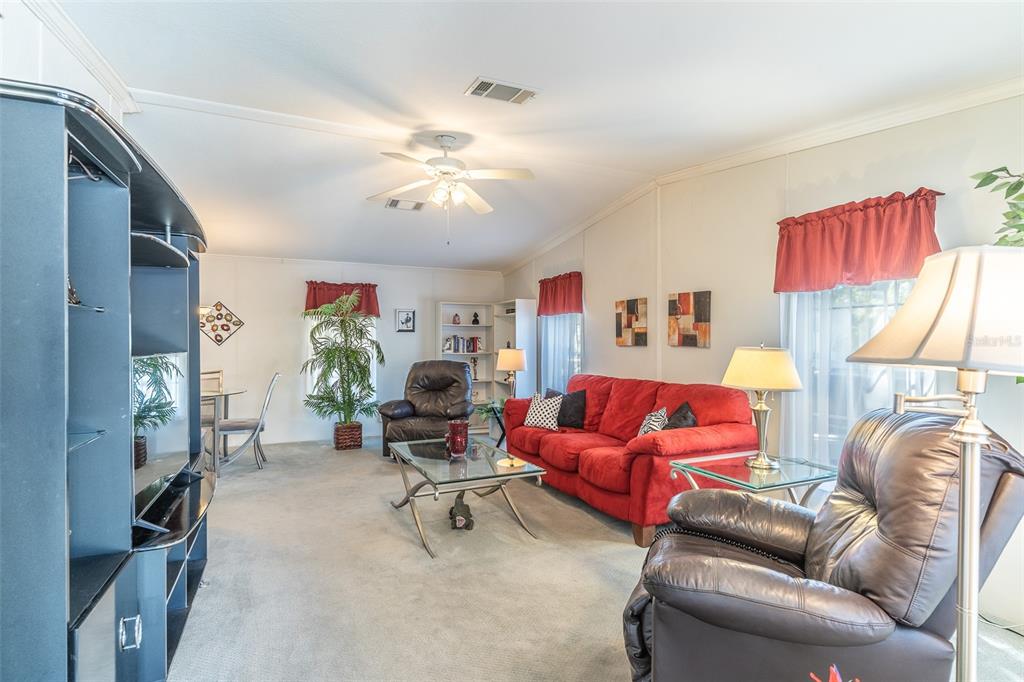 A living room features a red sofa, two leather recliners, and a glass coffee table — 13 SILVERSIDES STREET, LAKE WALES, FL