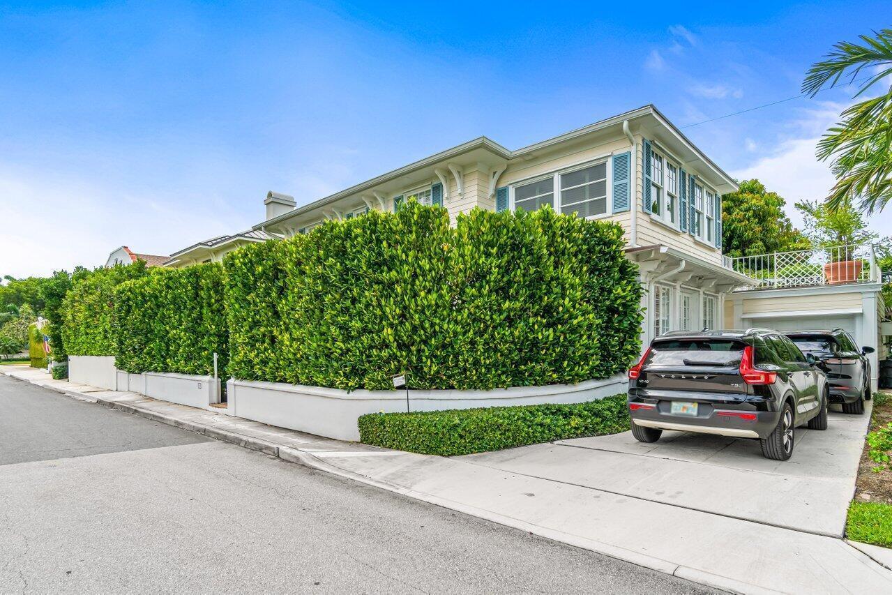 A two-story house with light siding, blue shutters, and a tall hedge-lined driveway — 263 Park Avenue, Palm Beach FL 33480, PALM BEACH, FL