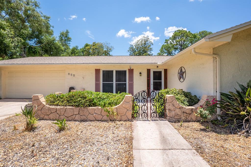 A single-story house with a beige stucco exterior, a garage, and a decorative stone wall — 113 FARRAGUT DRIVE, PALM COAST, FL