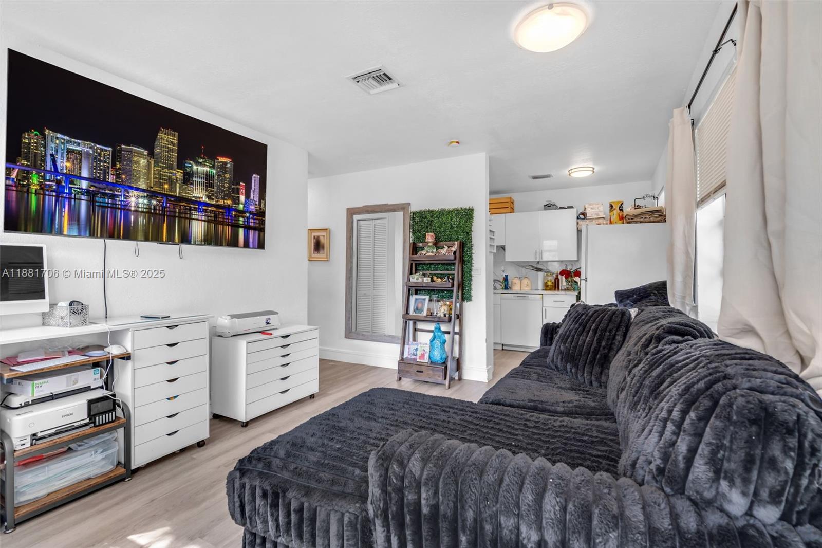A living room features a large television, a dark textured sectional, and white storage cabinets — 3380 NW 8th Pl, Lauderhill FL 33311, LAUDERHILL, FL