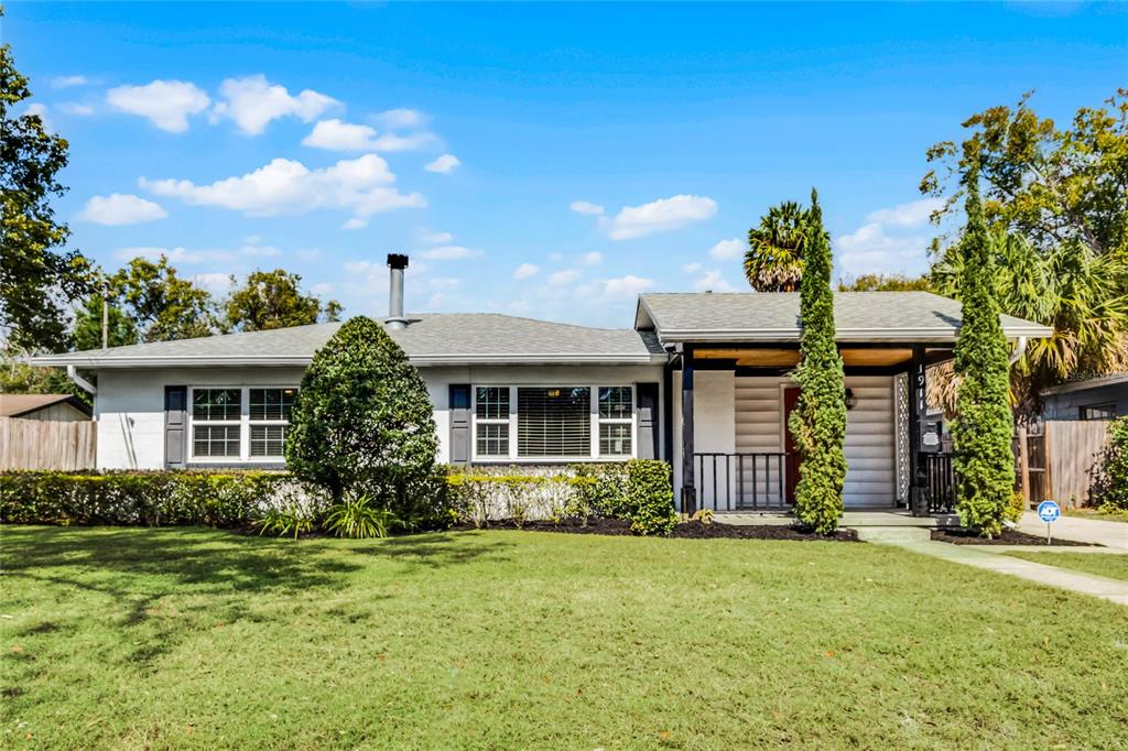 A single-story house with a white exterior, a covered porch, and a green lawn — 1911 CANTON STREET, ORLANDO, FL