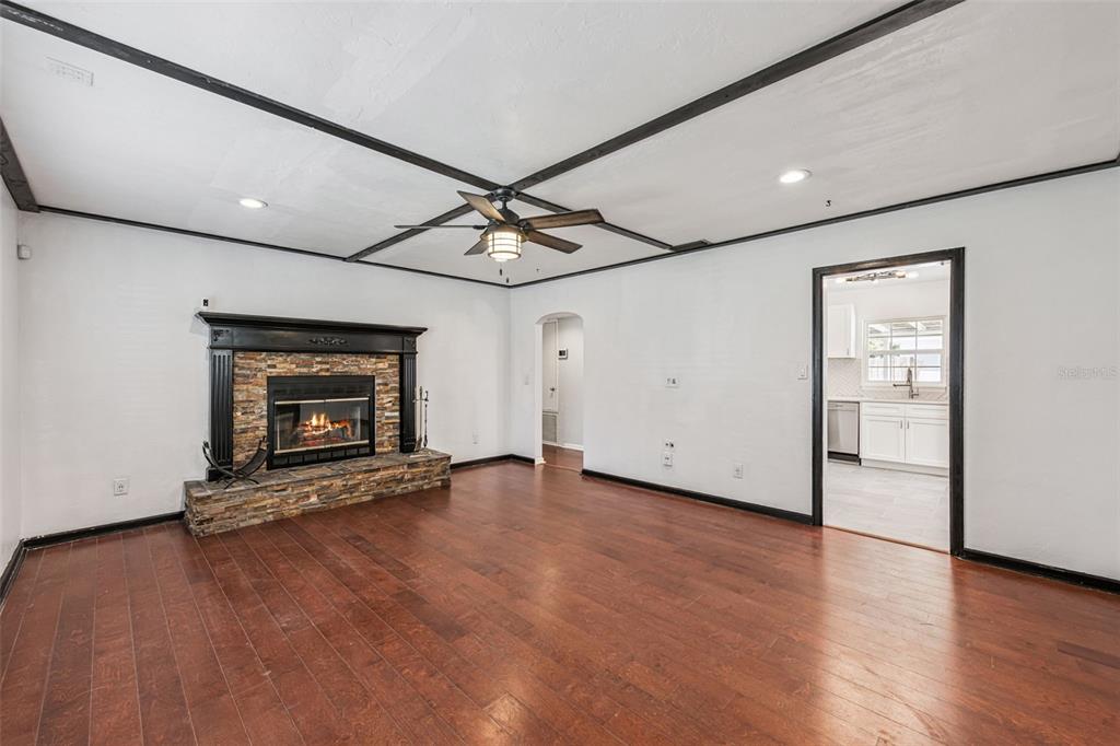 A living room features a stone fireplace, dark wood flooring, and a ceiling with black beams — 1911 CANTON STREET, ORLANDO, FL