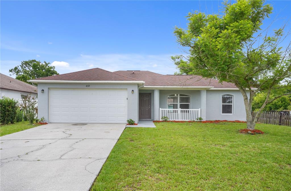 A single-story house with a gray exterior, a two-car garage, and a front porch — 4121 CANNON COURT, KISSIMMEE, FL