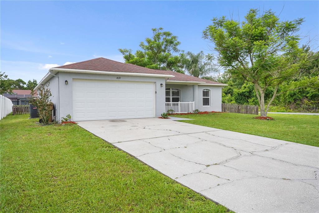 A single-story house with a gray exterior, a two-car garage, and a concrete driveway — 4121 CANNON COURT, KISSIMMEE, FL