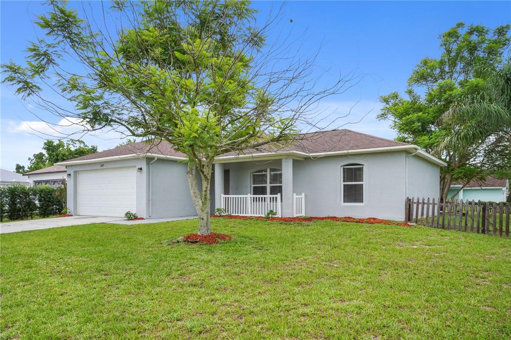 A single-story house with a light gray exterior, a two-car garage, and a front lawn — 4121 CANNON COURT, KISSIMMEE, FL