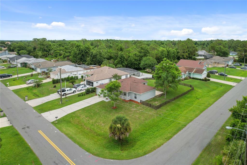 An aerial view shows a suburban neighborhood with houses, driveways, and surrounding green space — 4121 CANNON COURT, KISSIMMEE, FL