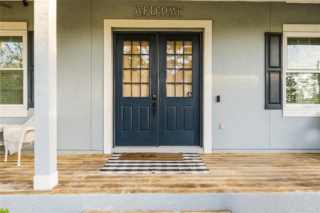 A light blue house exterior features a dark blue double front door and a porch — 19802 PEABODY STREET, ORLANDO, FL