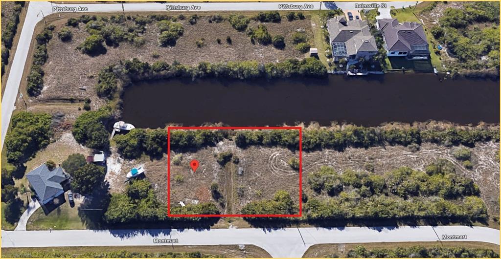 An aerial view shows a vacant rectangular lot outlined in red bordering a canal — 14315 MONTMARTE AVENUE, PORT CHARLOTTE, FL