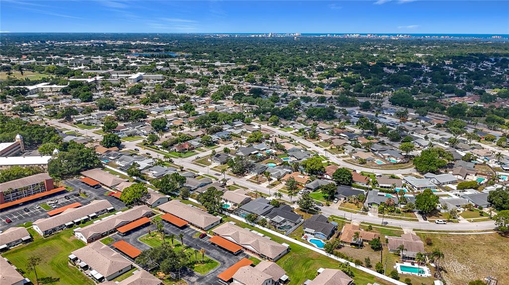 An aerial view shows a residential neighborhood with houses, apartment buildings, and swimming pools — 2474 ENTERPRISE ROAD UNIT 3, CLEARWATER, FL