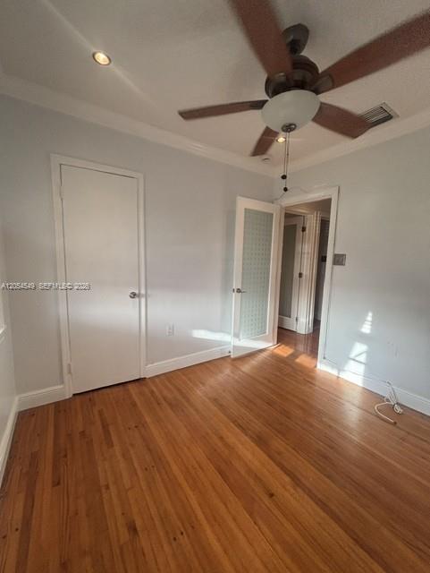An empty bedroom features hardwood floors, a ceiling fan, and two white interior doors — 14590 NW 10th Ave, Miami FL 33168, MIAMI, FL