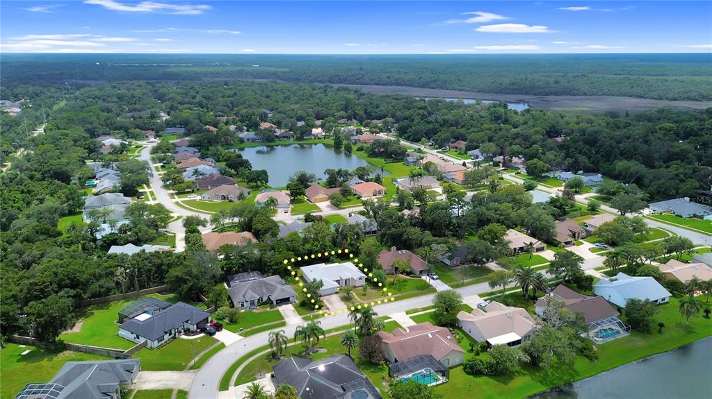 An aerial view shows a residential neighborhood with a highlighted single-story house and a lake — 516 SUN LAKE DRIVE, PORT ORANGE, FL