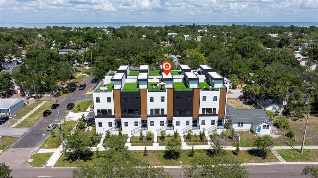 An aerial view shows a modern multi-unit townhouse complex with rooftop terraces and green spaces — 2104 4TH STREET S UNIT 3, ST PETERSBURG, FL