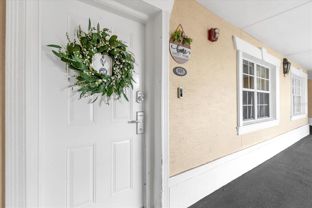 A white front door with a wreath and a unit number sign on a building — 1364 CENTRE COURT RIDGE DRIVE UNIT 101, REUNION, FL