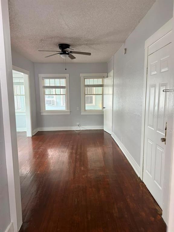 An empty room with hardwood floors, a ceiling fan, and two windows on the back wall — 308 GROVE STREET N UNIT 205, ST PETERSBURG, FL
