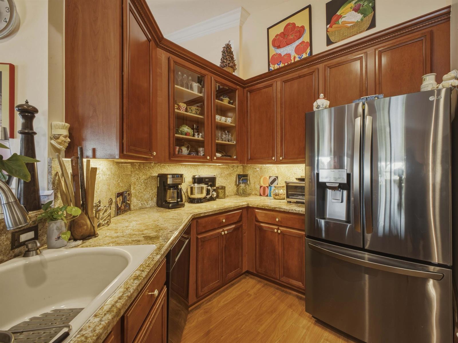 A kitchen features wood cabinets, granite countertops, stainless steel appliances, and a white sink — 8328 GRAND MESSINA Circle, Boynton Beach FL 33472, BOYNTON BEACH, FL