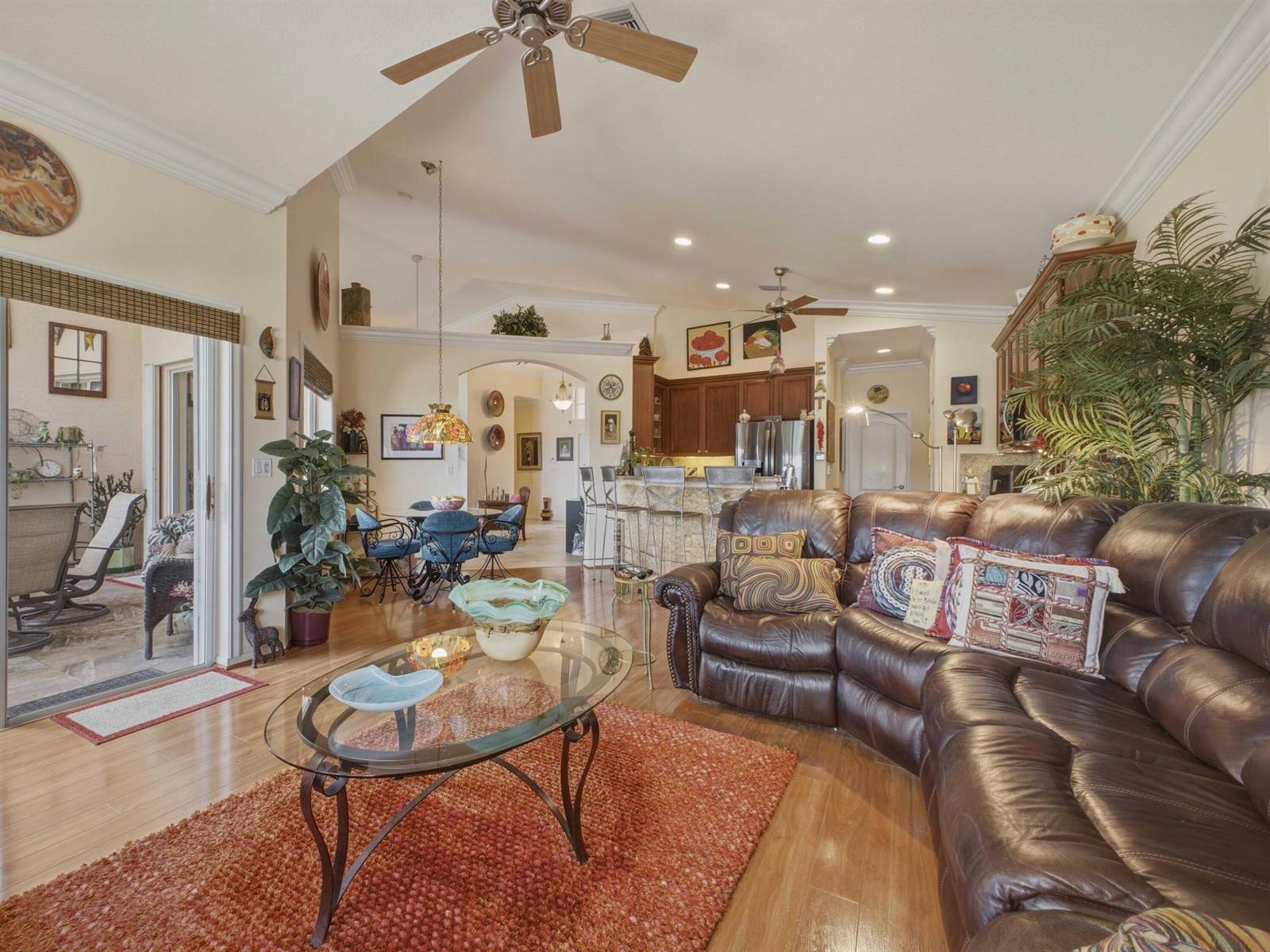 A living room with a brown leather sectional, glass coffee table, and an open kitchen — 8328 GRAND MESSINA Circle, Boynton Beach FL 33472, BOYNTON BEACH, FL