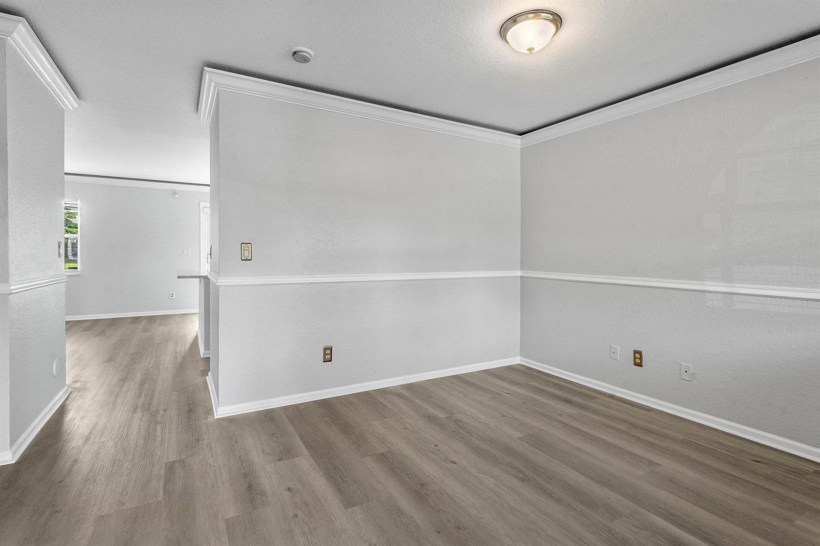 An empty room with light gray walls, white trim, and wood-look flooring — 3260 Commodore Court, West Palm Beach FL 33411, WEST PALM BEACH, FL